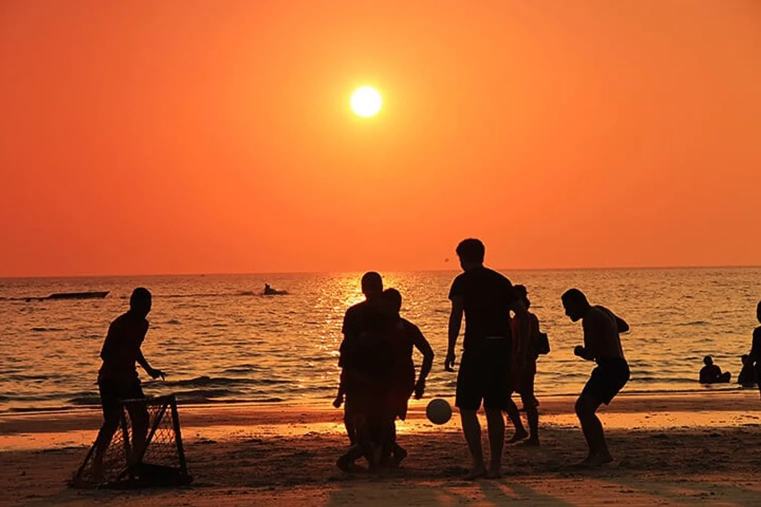 Locals enjoying football and sunset at Kuta Beach, Langkawi