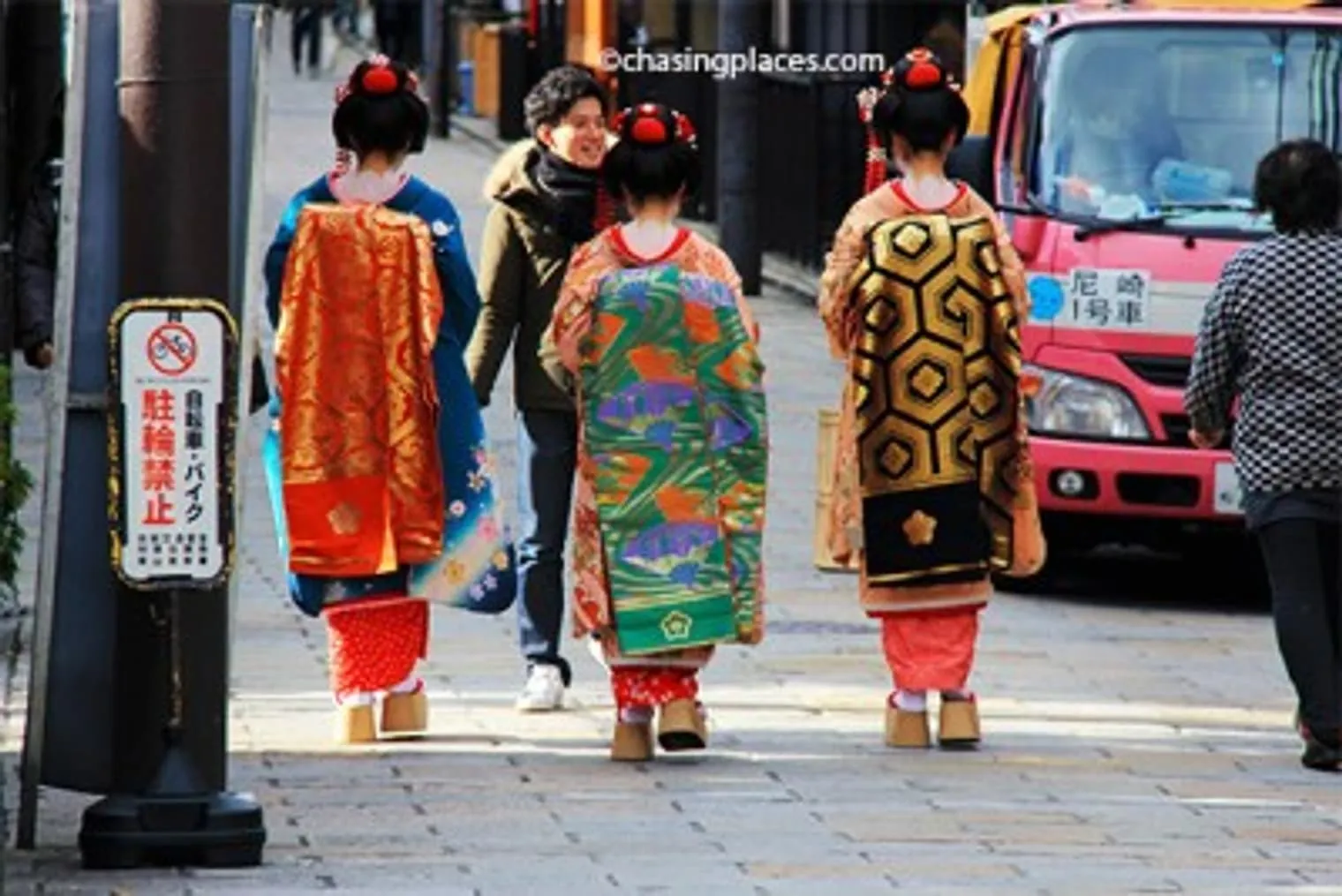 A local photographer preparing for a shoot with three dressed up locals