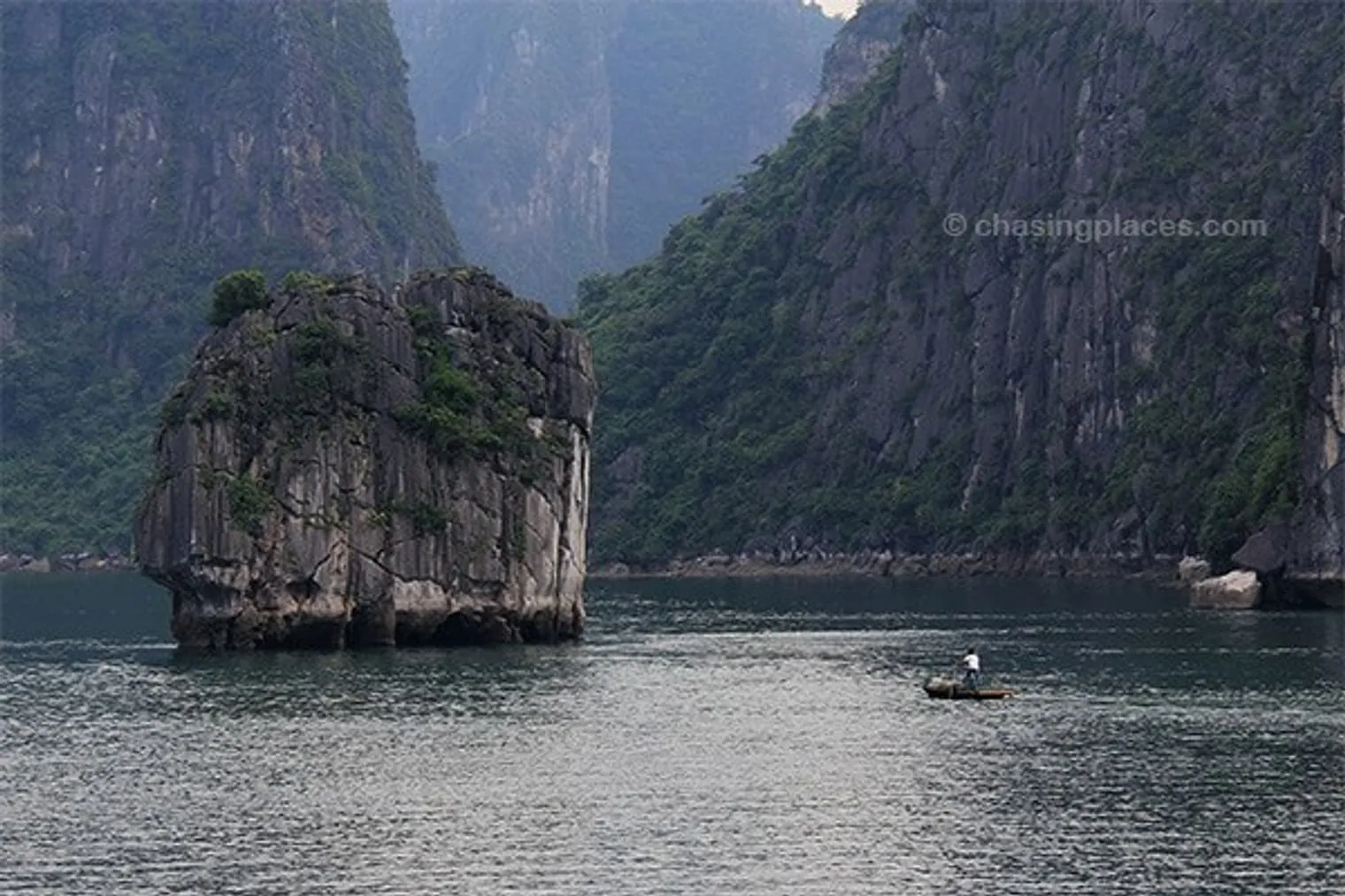 A local fisherman near a limestone outcropping in Halong Bay