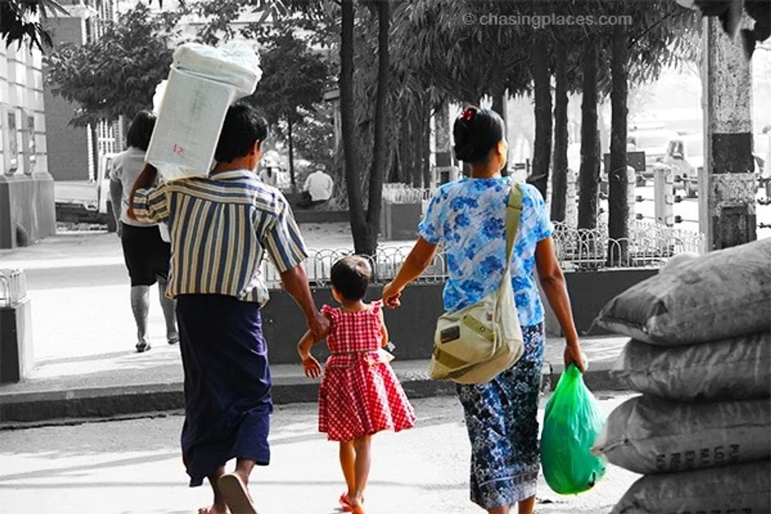 Walking in front of the foreign embassies and government buildings near Sule Pagoda, this young family gaze at the congested street action to their immediate right.